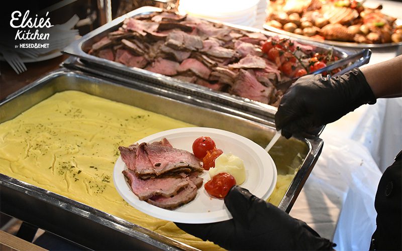 Catering staff serving sliced roast beef at a wedding