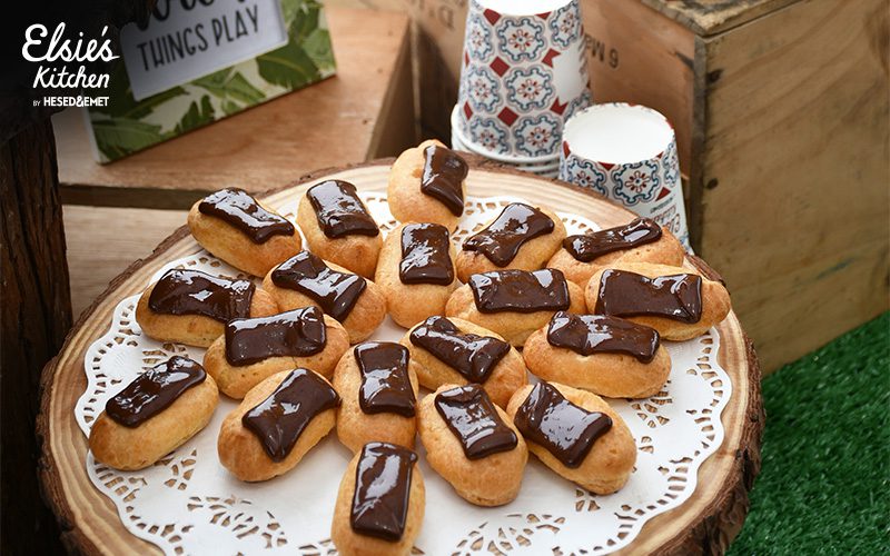 Chocolate eclairs served on a rustic wooden platter
