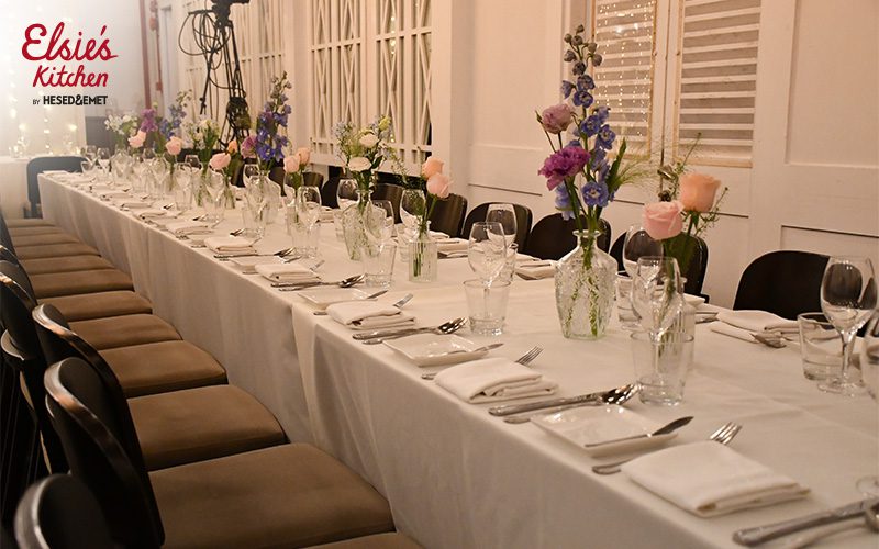 Long wedding banquet table featuring glamorous floral centerpieces