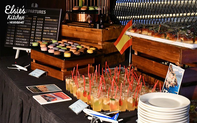 Travel-themed dessert display featuring colorful macarons and flight decor