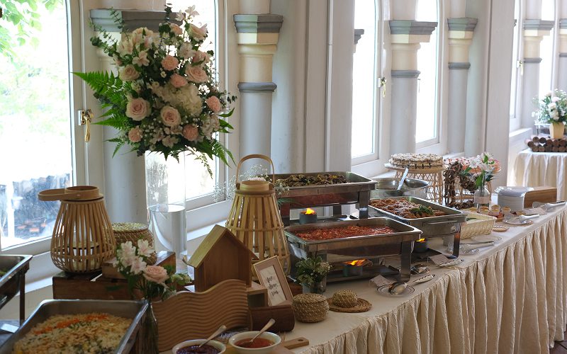 Elegant floral-themed buffet line with warm lighting and decor.