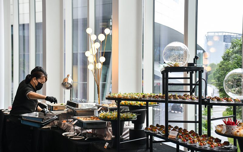 Catering staff preparing a buffet spread for a small gathering.