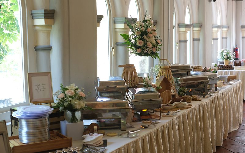Elegant buffet line featuring floral decor and heated serving trays.
