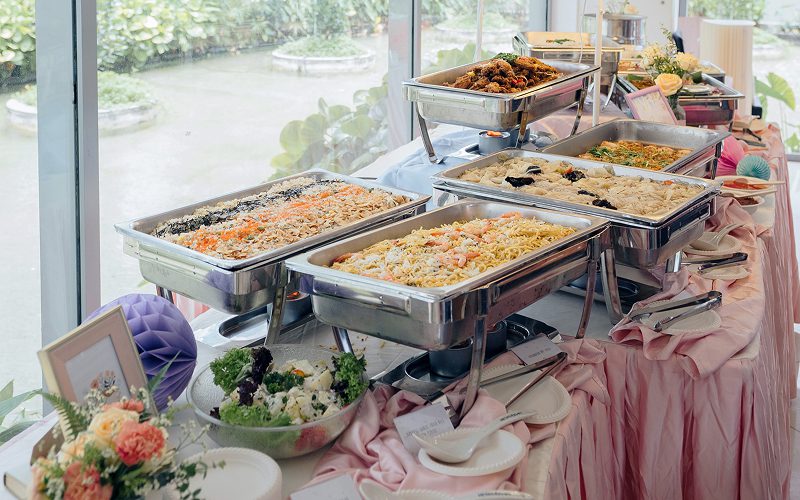 Variety of rice and noodle dishes at a catering event.