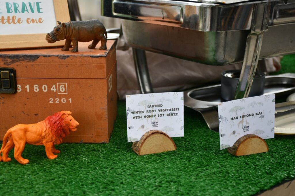 Close-up of kid-friendly catered food with jungle animal toys.