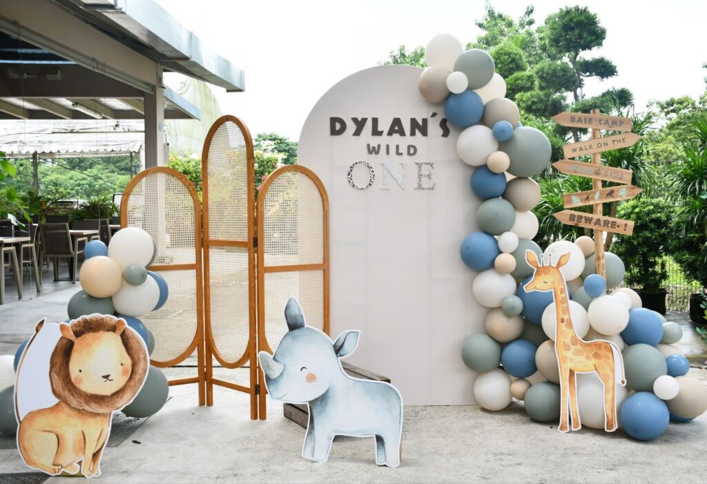 Safari themed first birthday party backdrop with animal cutouts.