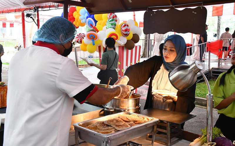 Elsie Kitchen chef serving fresh food at outdoor event.