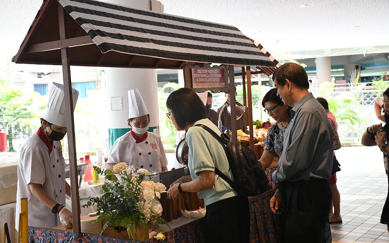 Elsie's Kitchen chefs serving guests at outdoor live station.