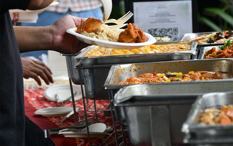 Guest filling plate at a space-smart housewarming buffet station.